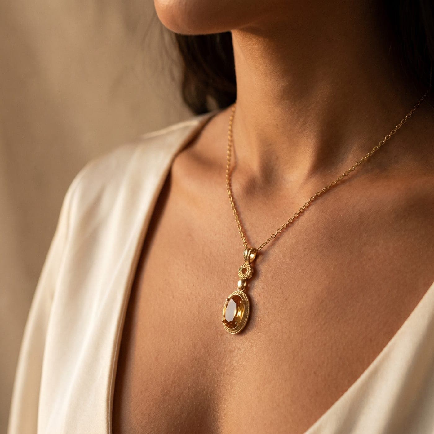 Colección Colección Etruria: joya bañada en oro de la línea sobre seda crema, a la luz cálida
