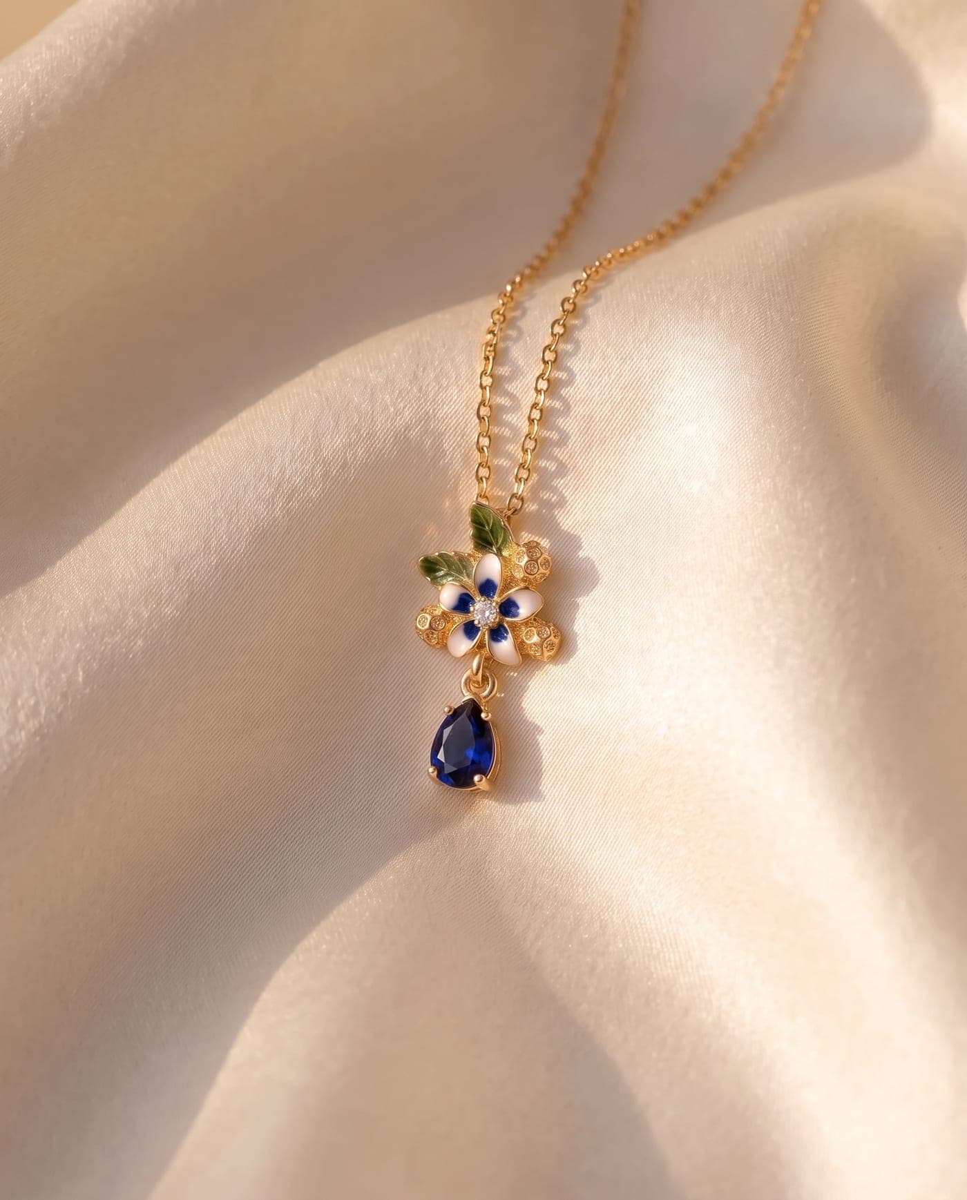 Colección Colección Flora Mini: joya bañada en oro de la línea sobre seda crema, a la luz cálida