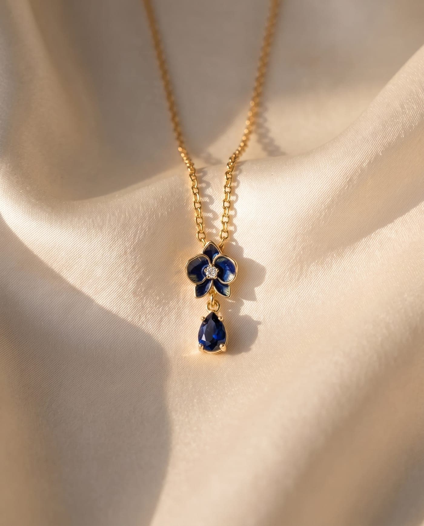 Colección Colección Orquídea: joya bañada en oro de la línea sobre seda crema, a la luz cálida